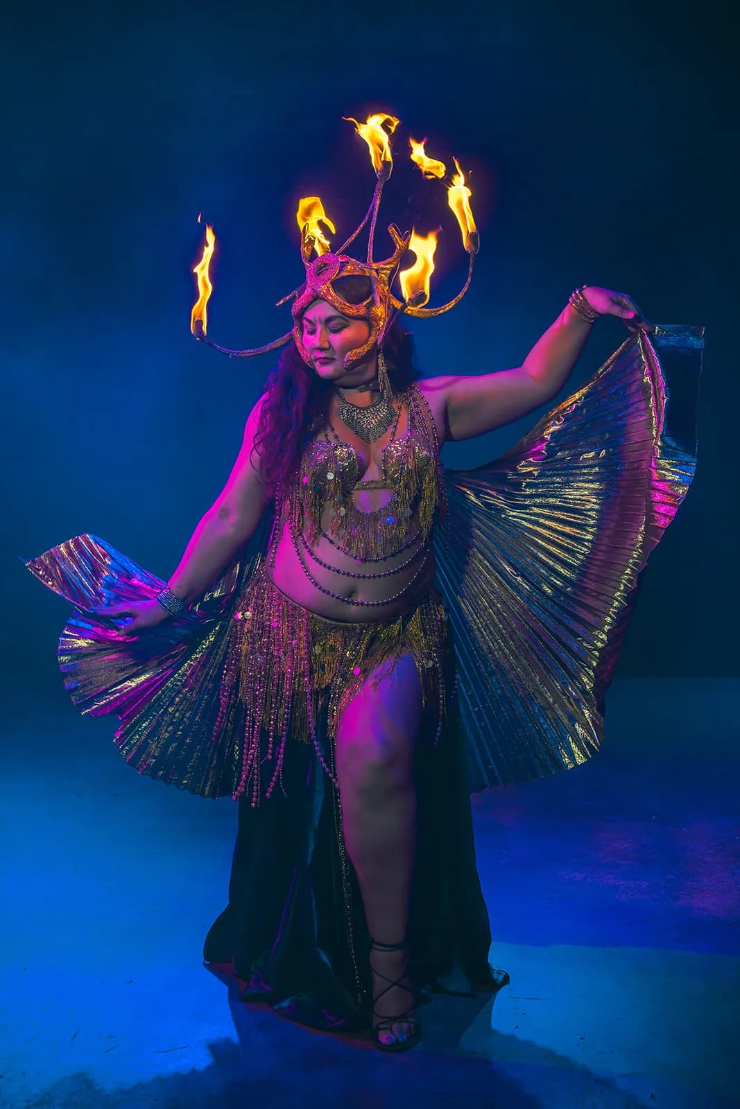 Lorenda performing in a flaming headdress with iridescent fusion dance wings